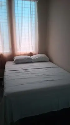a bed in a room with a window at Hostal primaveras nest in Santa Ana