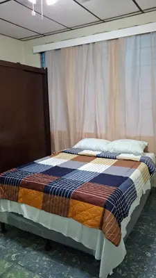 a large bed in a room with a curtain at Hostal primaveras nest in Santa Ana