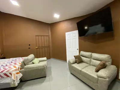 a bedroom with a bed and a couch and a tv at El Mangal 2 B&B in Suchitoto