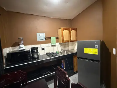 a small kitchen with a counter and a refrigerator at El Mangal 2 B&B in Suchitoto