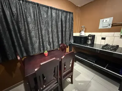 a kitchen with a table and a chair in front of a window at El Mangal 2 B&B in Suchitoto