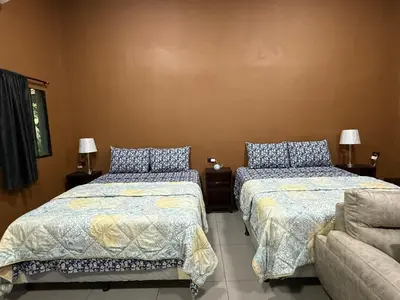 a bedroom with two beds and a couch at El Mangal 2 B&B in Suchitoto