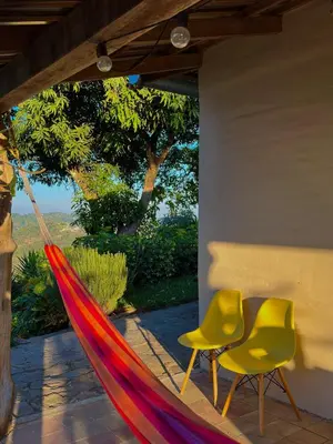 a hammock and two chairs on a patio at Finca Santa Lucía - Comasagua - Surf City Highlands in Comasagua