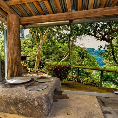 an outdoor patio with a stone stove and trees at Finca Santa Lucía - Comasagua - Surf City Highlands in Comasagua