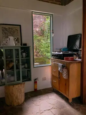 a kitchen with a window and a dresser and a tv at Finca Santa Lucía - Comasagua - Surf City Highlands in Comasagua