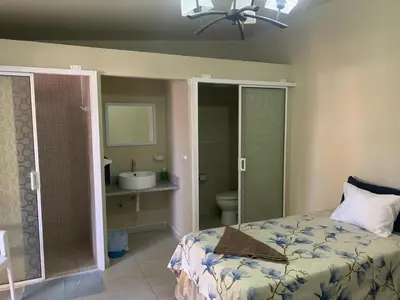 a bedroom with a bed and a bathroom with a sink at Rincon del mar in La Libertad