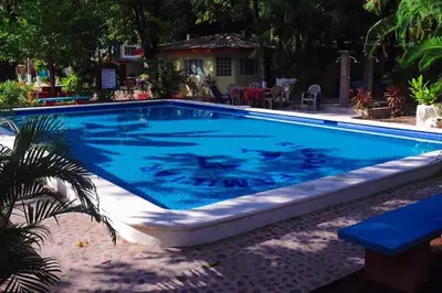 a large swimming pool with blue water in a yard at Rincon del mar in La Libertad