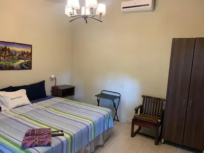 a bedroom with a bed and a chair and a cabinet at Rincon del atardecer in La Libertad