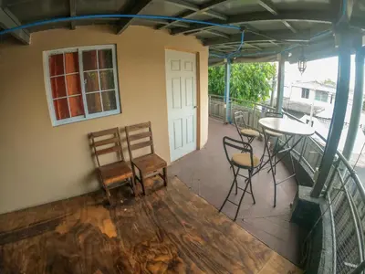 a room with a balcony with chairs and a table at Suite panorámica con terraza in San Salvador