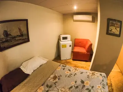 a small room with a bed and a chair at Suite panorámica con terraza in San Salvador