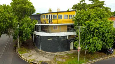 a yellow building with a fence in front of it at Suite panorámica con terraza in San Salvador