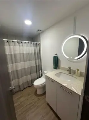 a bathroom with a toilet and a sink and a mirror at Cielito Lindo, vista espectacular en 11 nivel in Antiguo Cuscatlán