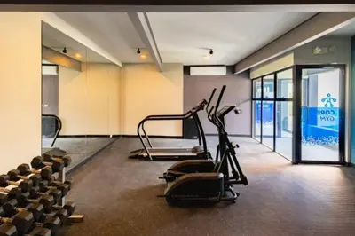 a gym with cardio equipment in a room with chairs at Cielito Lindo, vista espectacular en 11 nivel in Antiguo Cuscatlán