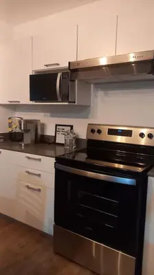 a kitchen with a black stove and a microwave at Cielito Lindo, vista espectacular en 11 nivel in Antiguo Cuscatlán