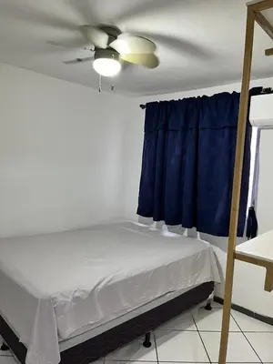 a bedroom with a bed and a ceiling fan at Todo cerca Apartamento Familiar en el corazón de San Salvador in San Salvador