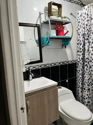 a bathroom with a toilet and a sink and a mirror at Todo cerca Apartamento Familiar en el corazón de San Salvador in San Salvador