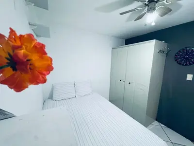 a bedroom with a bed and a flower on the wall at Todo cerca Apartamento Familiar en el corazón de San Salvador in San Salvador