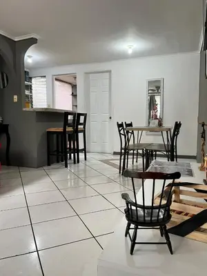 a living room with a table and chairs on a tile floor at Todo cerca Apartamento Familiar en el corazón de San Salvador in San Salvador