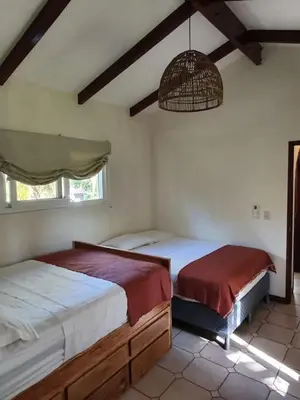 a bedroom with two twin beds and a fan at Villa San Juan, playa Costa Azul in Acajutla