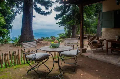 a table and chairs with a bowl of fruit on it at Finca Life - Surf City Highlands - Comasagua in Los Amates