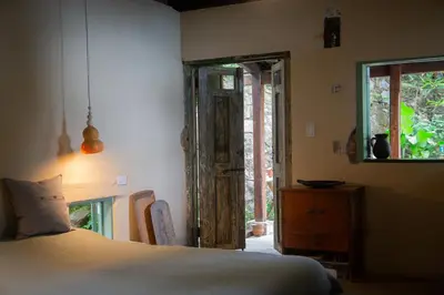 a bedroom with a bed and an open door at Finca Life - Surf City Highlands - Comasagua in Los Amates