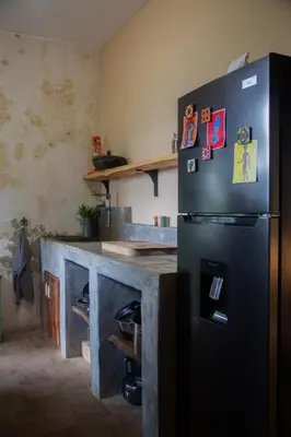 a kitchen with a refrigerator with magnets on it at Finca Life - Surf City Highlands - Comasagua in Los Amates