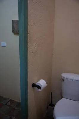 a bathroom with a toilet with a roll of toilet paper at Finca Life - Surf City Highlands - Comasagua in Los Amates