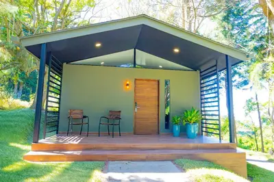 a small house with a deck with two chairs at Cajamarca Villas by Collection in Las Delicias