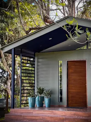 a house with a wooden door and three potted plants at Cajamarca Villas by Collection in Las Delicias