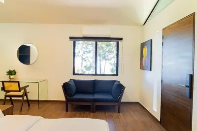 a bedroom with a blue chair and a window at Cajamarca Villas by Collection in Las Delicias