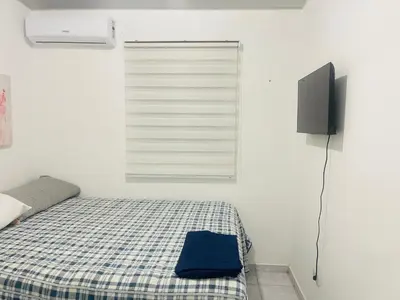 a bedroom with a bed with a tv and a window at Casa tonykey in San Miguel