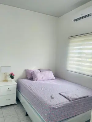 a bedroom with a bed with purple sheets and a window at Casa tonykey in San Miguel