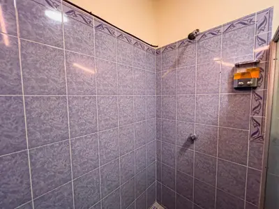 a bathroom with blue tiled walls and a shower at Coral Beach in Tamanique