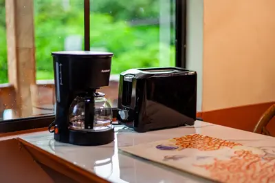 a coffee maker sitting on a counter next to a toaster at Coral Beach in Tamanique