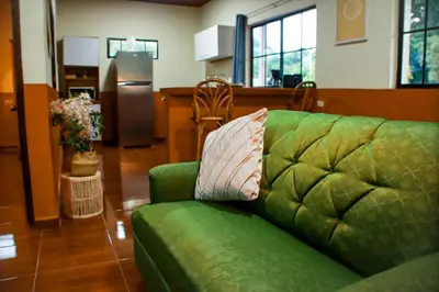 a green couch with a pillow on it in a living room at Coral Beach in Tamanique