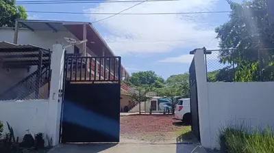 a house with a black door and a white fence at Coral Beach in Tamanique