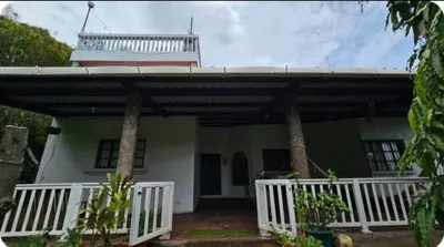 a house with a balcony on top of it at Jaco Mizata Beach and River in Las Piedras