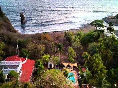 a view of a beach with a house and the ocean at Jaco Mizata Beach and River in Las Piedras