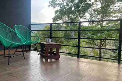 a balcony with two chairs and a table and a window at Apartment Casa Melodia in Chirilagua