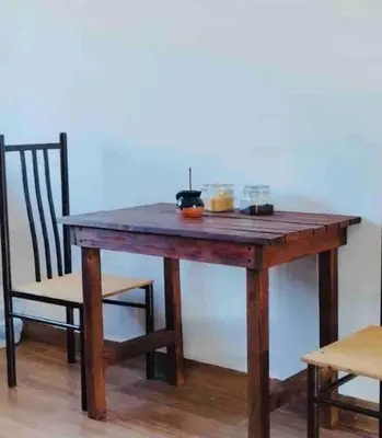 a wooden table with a chair and a table with food on it at Apartment Casa Melodia in Chirilagua