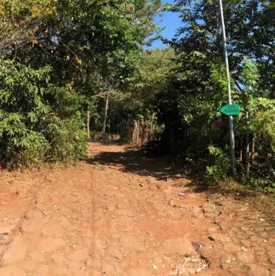 a dirt road with a green sign on a pole at Apartment Casa Melodia in Chirilagua