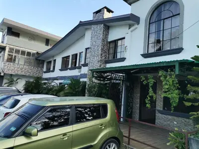 a green car parked in front of a house at Hotel Alicante San Salvador in Antiguo Cuscatlán