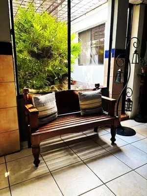 a bench sitting in front of a window at Hotel Alicante San Salvador in Antiguo Cuscatlán