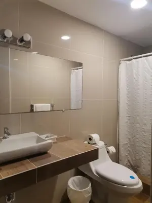 a bathroom with a toilet and a sink and a mirror at Hotel Alicante San Salvador in Antiguo Cuscatlán