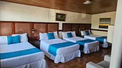 three beds in a room with blue pillows at Hotel Alicante San Salvador in Antiguo Cuscatlán