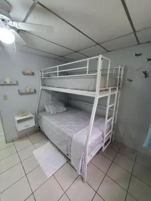a bedroom with a bunk bed and a white bunk bed at Casita Jardin in San Salvador