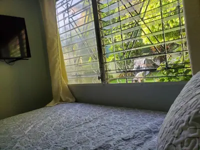 a bedroom with a bed and a window at Casita Jardin in San Salvador