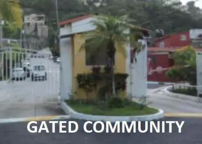 a street with a yellow house with a palm tree at Casita Jardin in San Salvador