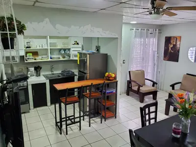 a kitchen with a table and chairs in a room at Casita Jardin in San Salvador
