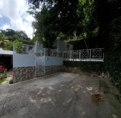 a house with a balcony and a driveway at Casita Jardin in San Salvador